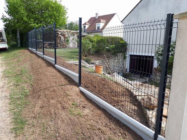 Pose d'une clôture en panneaux rigides avec plaques de soubassement béton